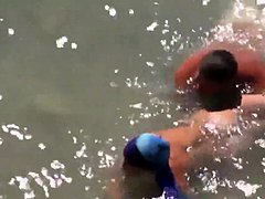 Girl sucks dick her boyfriend in the surf at a public beach
